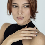 A clear base coat and black nail polish wraps on fingers, posing against a white background.